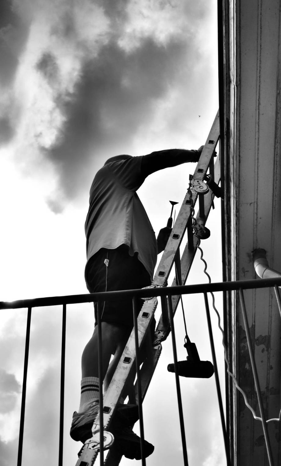 low-angle-view-men-standing-ladder-against-sky